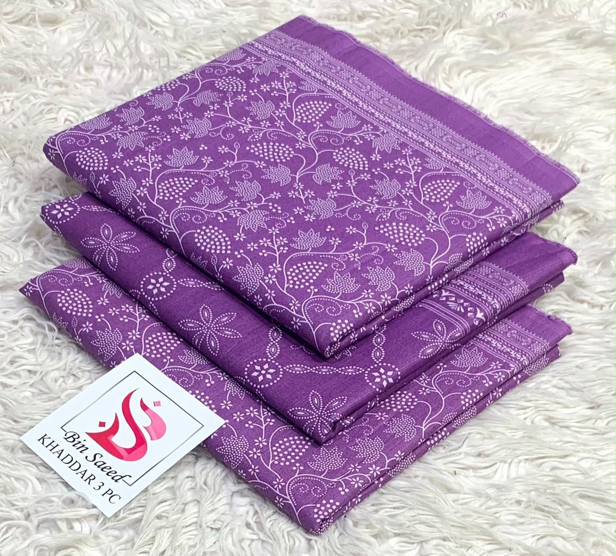 Folded amethyst purple Bin Saeed khaddar 3 piece unstitched suit with white botanical print.