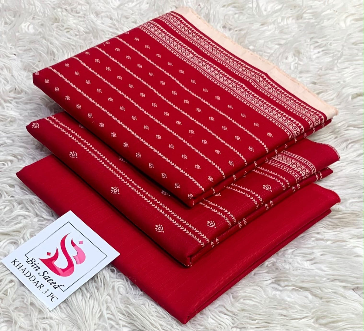 Folded crimson red Bin Saeed khaddar 3 piece unstitched suit with delicate white minimal print.