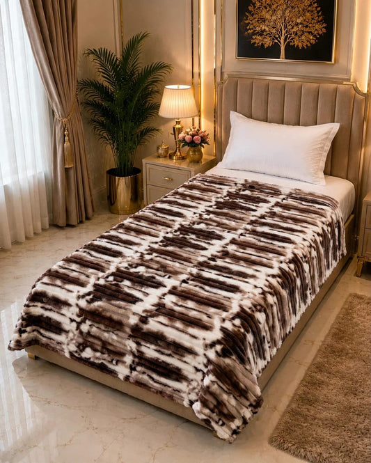 A single bed styled with a luxury AC blanket featuring a textured linear brown and white pattern.