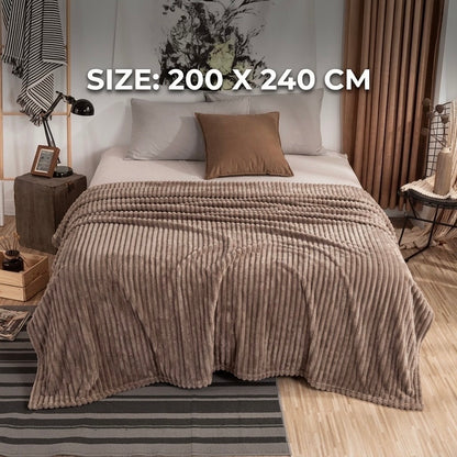 Warm beige luxury fleece AC blanket with a ribbed texture, draped gracefully over a modern double bed.
