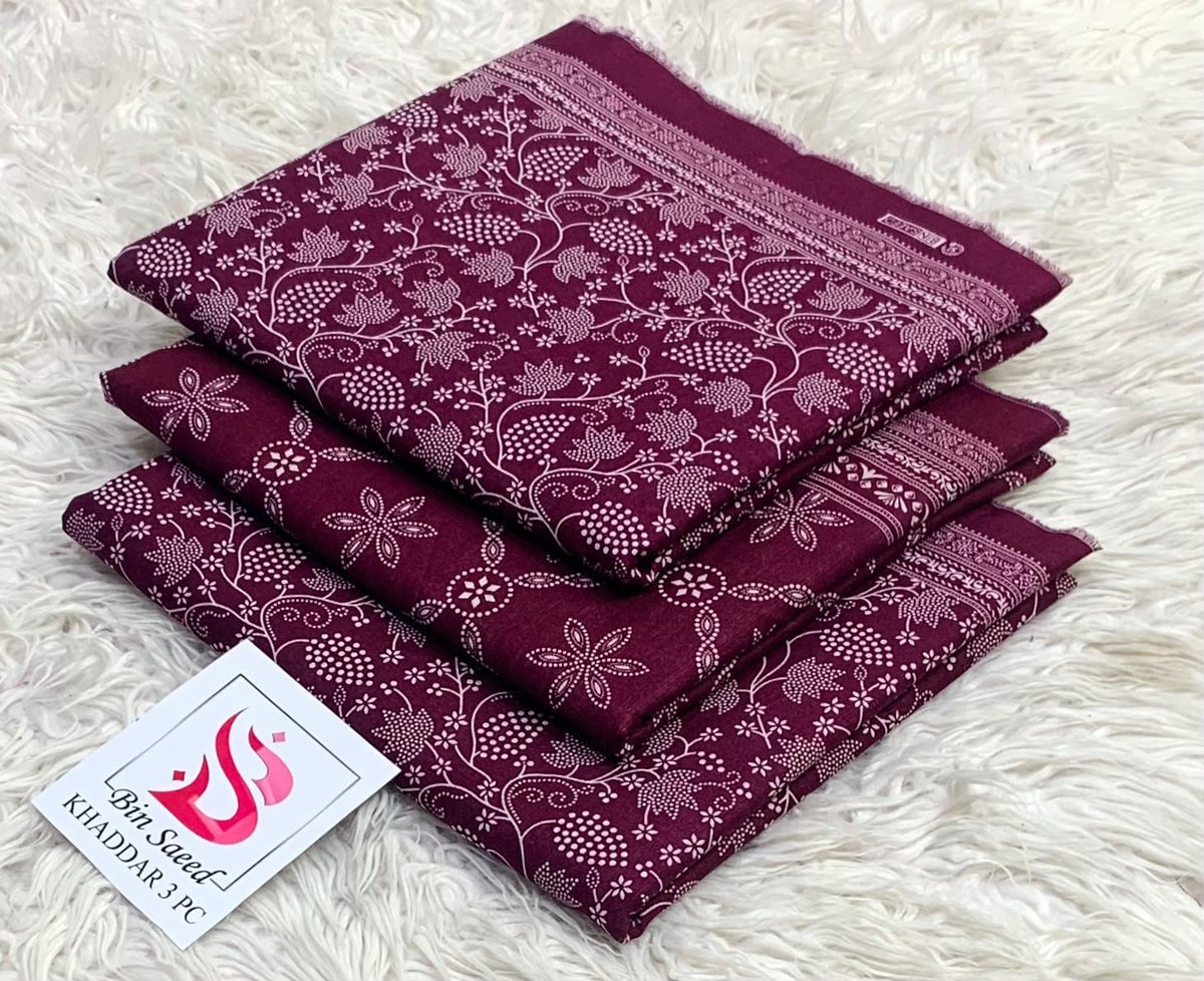 Folded plum burgundy Bin Saeed khaddar 3 piece unstitched suit with white floral prints.