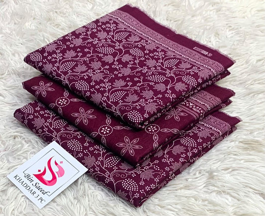 Folded plum burgundy Bin Saeed khaddar 3 piece unstitched suit with white floral prints.